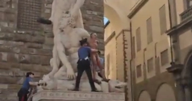 un hombre desnudo se subió a una estatua